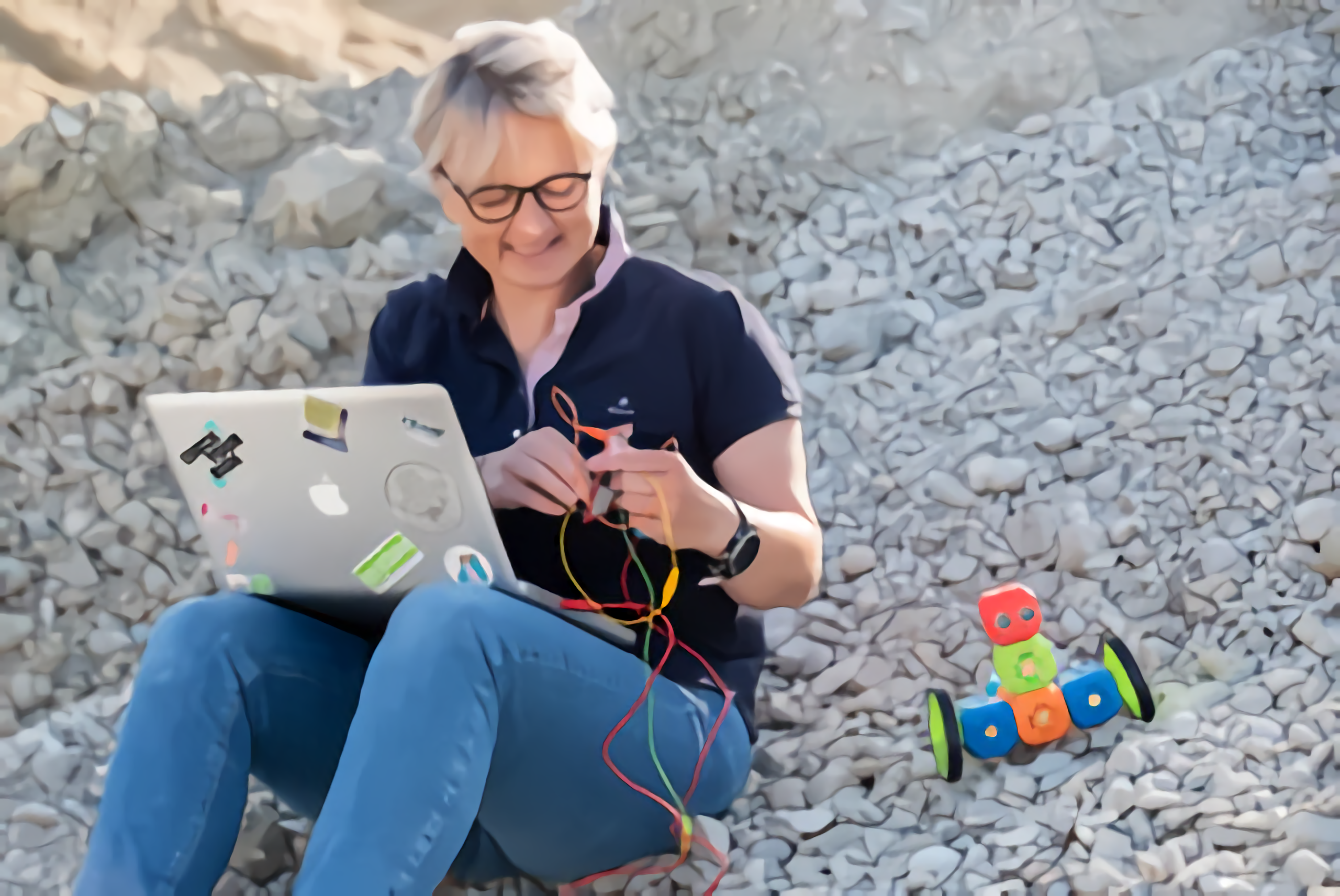 Katja sitzt mit Laptop auf einem Hügel image